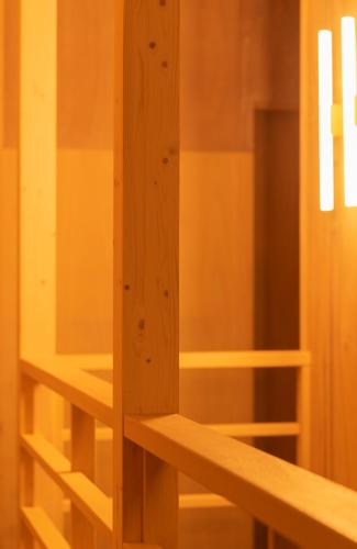 a wooden cabinet with wooden shelves in a room at BEACH AND FIELD INN in Sapporo