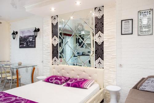 Pokój z łóżkiem z fioletowymi poduszkami i stołem w obiekcie Studio on Oliinyka Street w mieście Mikołajów