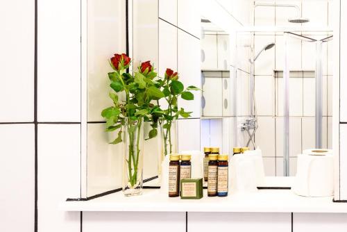 un jarrón con flores en un estante en un baño en Paskins Town House en Brighton & Hove