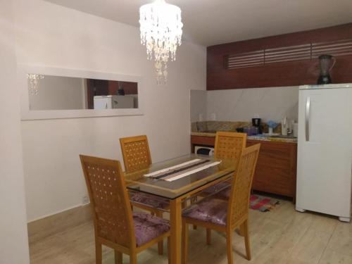 a kitchen with a table with chairs and a refrigerator at La Piazzetta di Pipa in Pipa