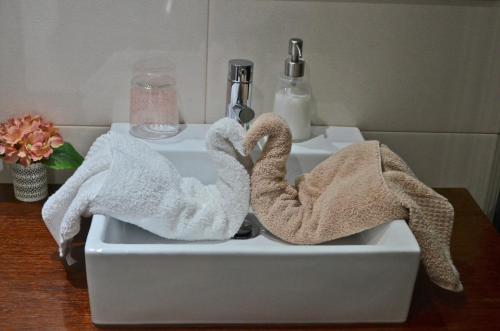two towels in a bathroom sink with two swans at Casa de Campo Sossego da Lata in Fafe