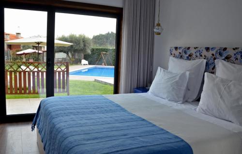 a bedroom with a bed and a view of a pool at Casa de Campo Sossego da Lata in Fafe
