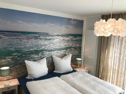 エッカーンフェルデにあるSEASIDE APARTMENTS - BEACHHOUSE WAVEの海の絵画が飾られたベッドルーム