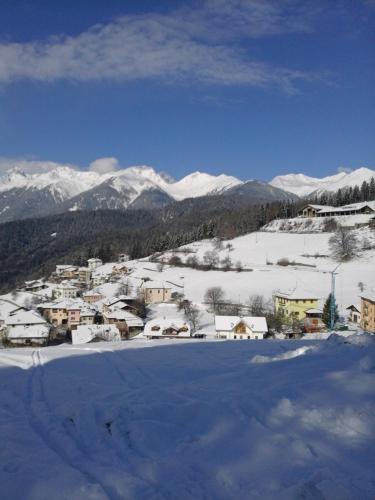 a town covered in snow with mountains in the background at CASA IDA - ClPAT 22253 in Tregiovo