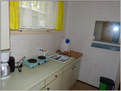 a kitchen with a counter with a sink and a blender at DDR Bungalow direkt am Strand auf Rügen in Dranske
