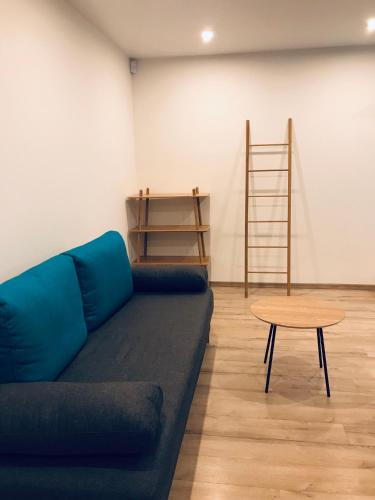 a living room with a blue couch and a table at TF Apartment двокімнатні апартаменти в центрі міста in Poltava