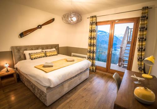 a bedroom with a bed and a large window at The Vaujany Mountain Lodge in Vaujany