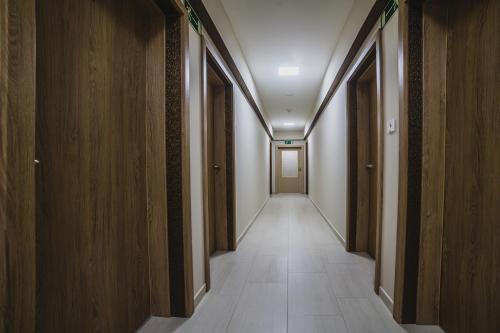 a hallway with wooden walls and a long hallway with white tiles at Sztár Motel Étterem in Balassagyarmat