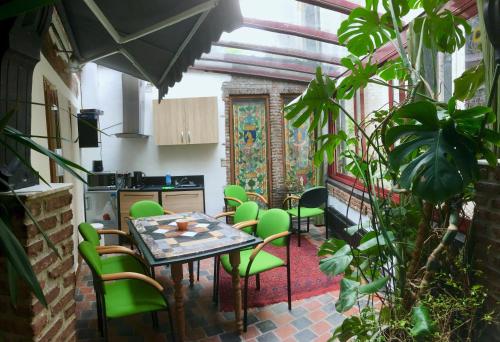 een keuken met een tafel en groene stoelen in een kamer bij Kathedraallogies Drie Koningen in Antwerpen