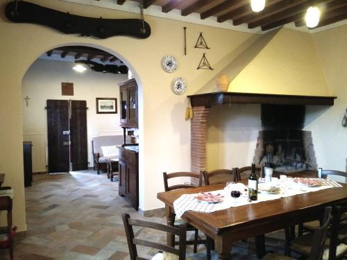 a dining room with a table and a fireplace at Podere Il Leccione in Palaia