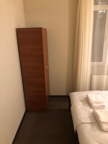 a small bedroom with a bed and a door at El Mundo Apartments in Lviv