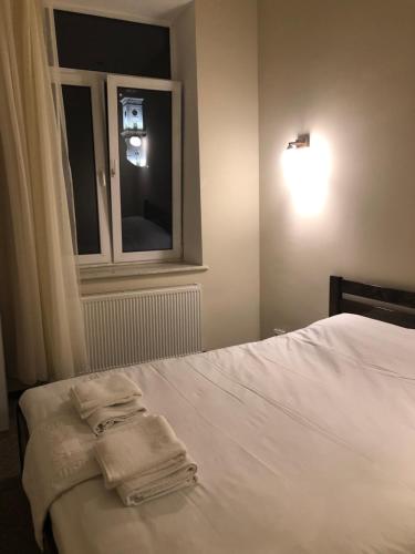 a bedroom with a bed with two towels on it at El Mundo Apartments in Lviv