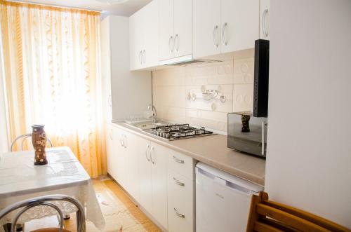 a kitchen with white cabinets and a stove top oven at Garsoniera Jad in Tîrgu Ocna