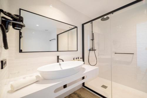 a white bathroom with a sink and a shower at Hotel Sa Clau by Mambo in San Antonio