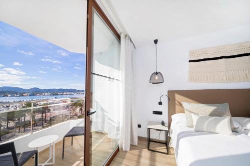 a bedroom with a bed and a view of the ocean at Hotel Sa Clau by Mambo in San Antonio