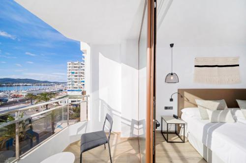 a bedroom with a bed and a balcony with a view at Hotel Sa Clau by Mambo in San Antonio