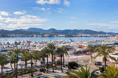 a city with palm trees and a harbor at Hotel Sa Clau by Mambo in San Antonio