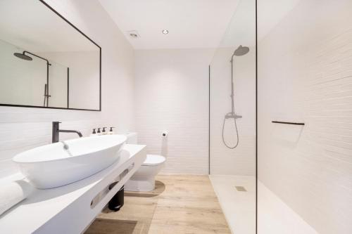 a white bathroom with a sink and a shower at Hotel Sa Clau by Mambo in San Antonio