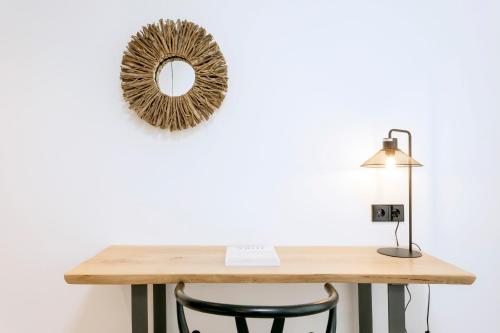 a table with a mirror and a lamp at Hotel Sa Clau by Mambo in San Antonio