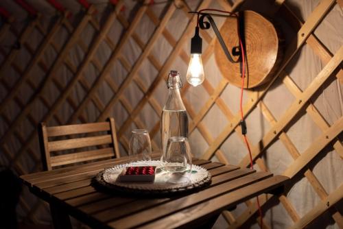 a table with a lamp and a bottle on it at Quinta do Ragal in Lavacolhos