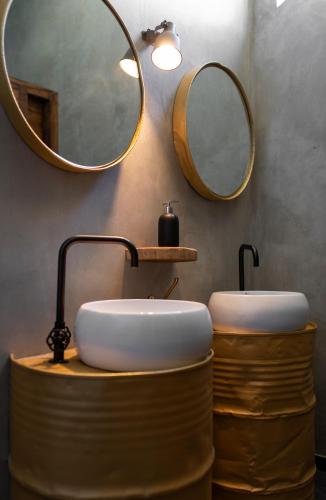a bathroom with a sink and two mirrors on the wall at Quinta do Ragal in Lavacolhos