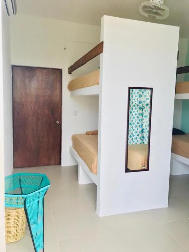 a room with a bed and a mirror and a table at Paziflora Hostel -STARLINK- in Puerto Escondido