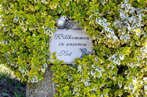 a sign in a bush with a bird on it at Ferienwohnung Kochs Beeren in Oberfresen