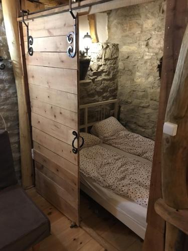 a bed in a room with a wooden wall at Fűtetős Dombház in Üröm