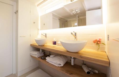 a bathroom with two sinks and a mirror at Cottage Markdal in Breda