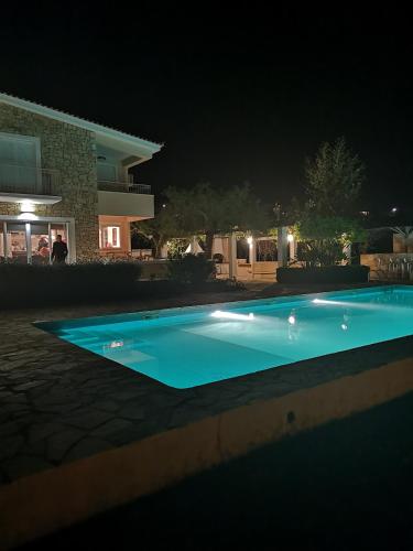 a swimming pool in front of a house at night at Luxury Villa Flora Kiparissia in Kyparissia