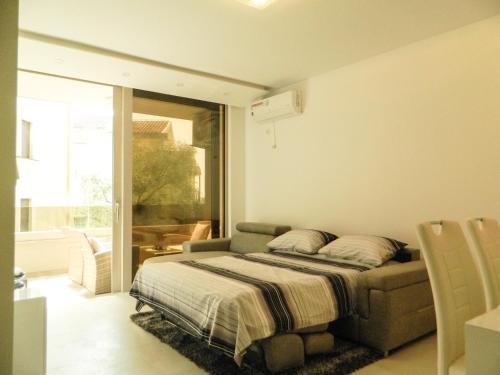 - une chambre avec un lit et une grande fenêtre dans l'établissement Lux Apartment Teodora Rafailovici, à Rafailovici