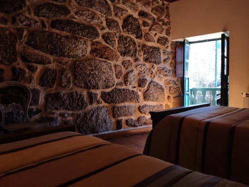 a room with a stone wall and a window at Casa Padre Alexandre in Covide