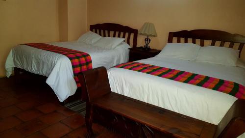 two beds sitting next to each other in a room at Posada Papa Chepe in La Esperanza