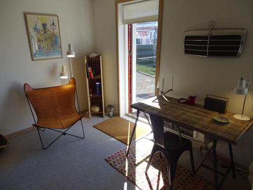 a room with a desk and a chair and a window at Fin lejlighed med lukket have in Skagen