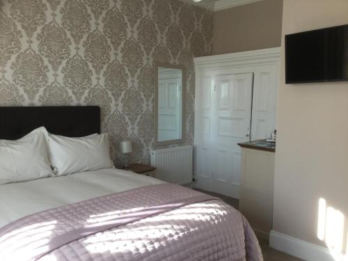 A bed or beds in a room at Glenora Guest House 