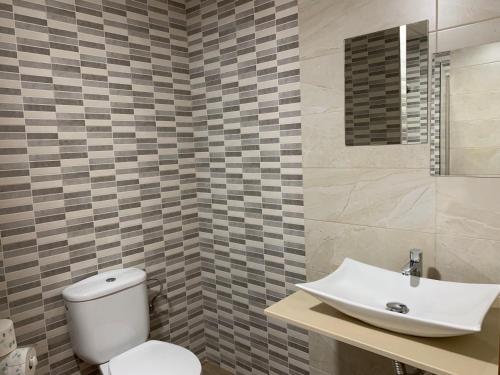 La salle de bains est pourvue de toilettes blanches et d'un lavabo. dans l'établissement Hostal Restaurante Rufino, à Berlanga