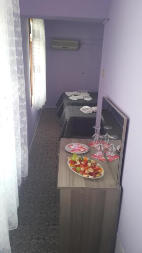 a room with two beds and a plate of fruit on a counter at Grand Yayla Hotel in Cesme