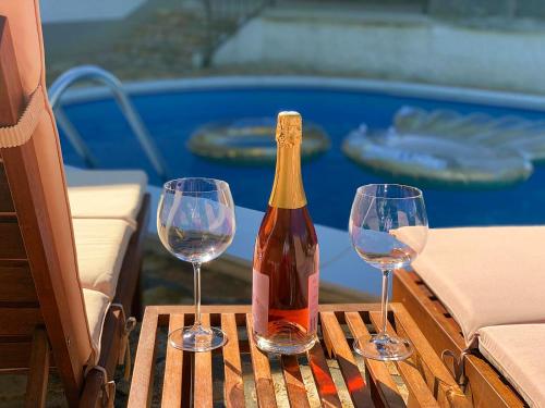 una botella de vino y dos copas de vino en una mesa en Holiday Home Deni, en Roč