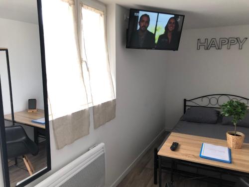 a room with a bed and a desk with a happy sign at Capstay famars & Netflix in Famars