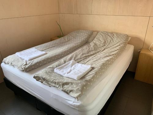 Una cama con dos toallas blancas encima. en Apartment in the country, great view Apt. A, en Akureyri