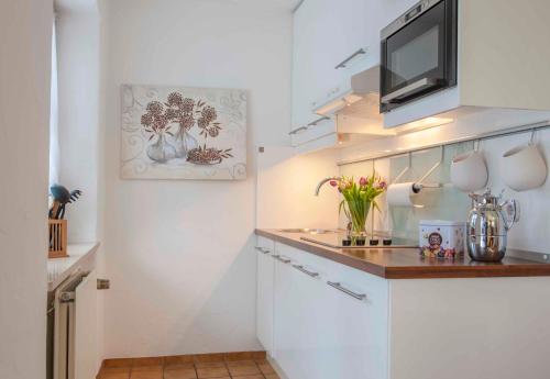 a small white kitchen with a counter and a microwave at Am Sonneneck - Wohnung 1 in Ruhpolding