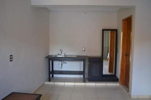 Cette chambre comprend une table, un miroir et un lavabo. dans l'établissement Hotel Kinich Ahau, à Valladolid