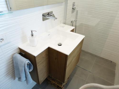 une salle de bains avec un lavabo blanc et une douche dans l'établissement Vittoria home 44, à Terracine