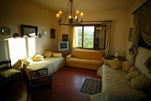 a living room with a couch and a bed and a window at Agriturismo Ridocco in Corleone