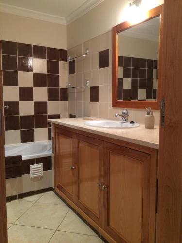 ein Badezimmer mit Waschbecken, Badewanne und Spiegel in der Unterkunft Gomeira Top Floor in Cabanas de Tavira