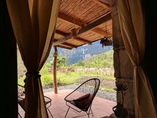 a porch with chairs and a view of a mountain at Mamaq Tambo Lodge in Cocachimba