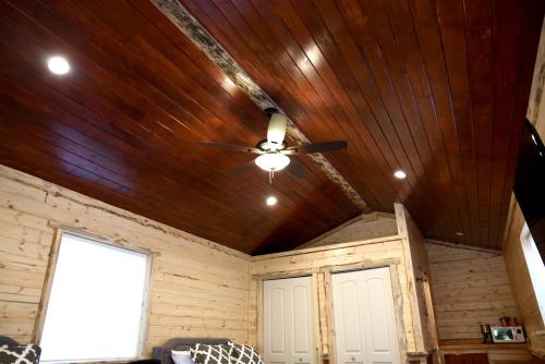 a ceiling fan in a room with wooden ceilings at Gateway Inn & Cabins in Ashford