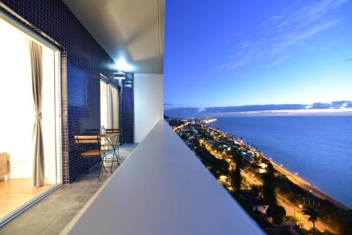 a room with a view of the ocean and a balcony at Xenon Urban Apartments in Maputo