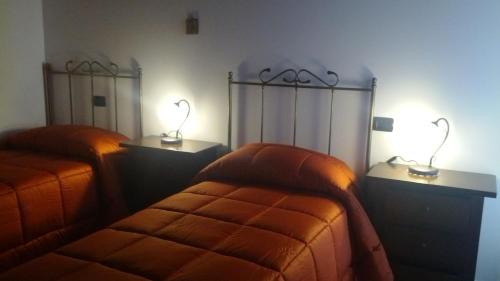 two beds in a room with two lamps on them at Antica Interamnia in Teramo