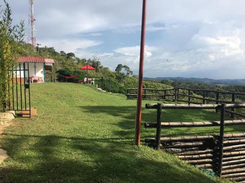 a fence on the side of a grassy hill at La cabaña del lago Calima in Calima